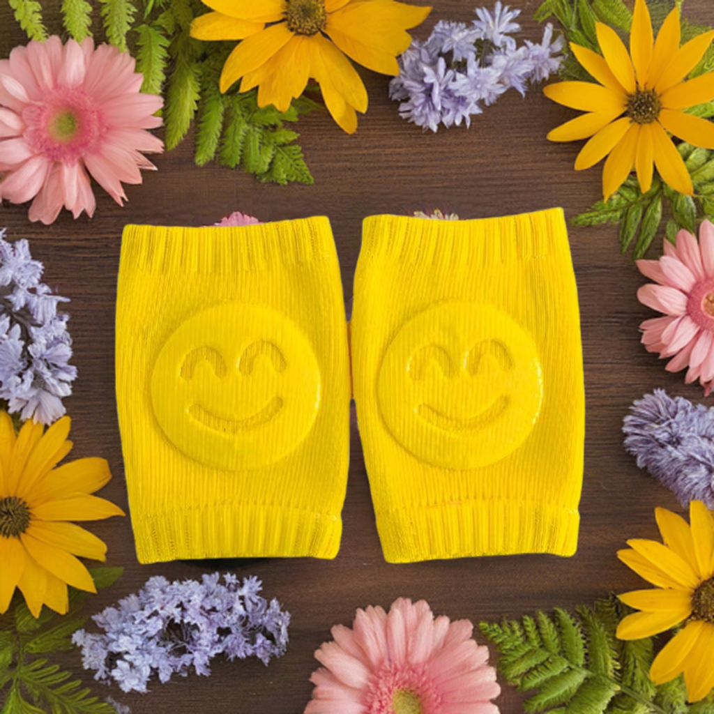 vibrant image featuring two yellow knitted kneepads with smiley faces in the center, yellow wristbands, smiley face design, colorful flowers, gerberas, daisies, lavender, knitted accessories, wooden background