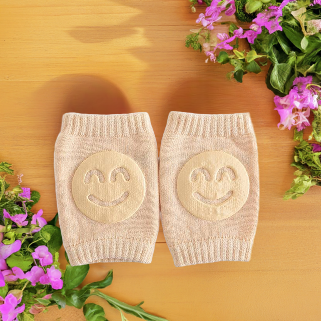 beige knee pads with smiley face designs placed on a wooden surface, beige knee pads, smiley face design, protective gear, wooden surface, purple flowers, safety equipment, comfortable knee protection