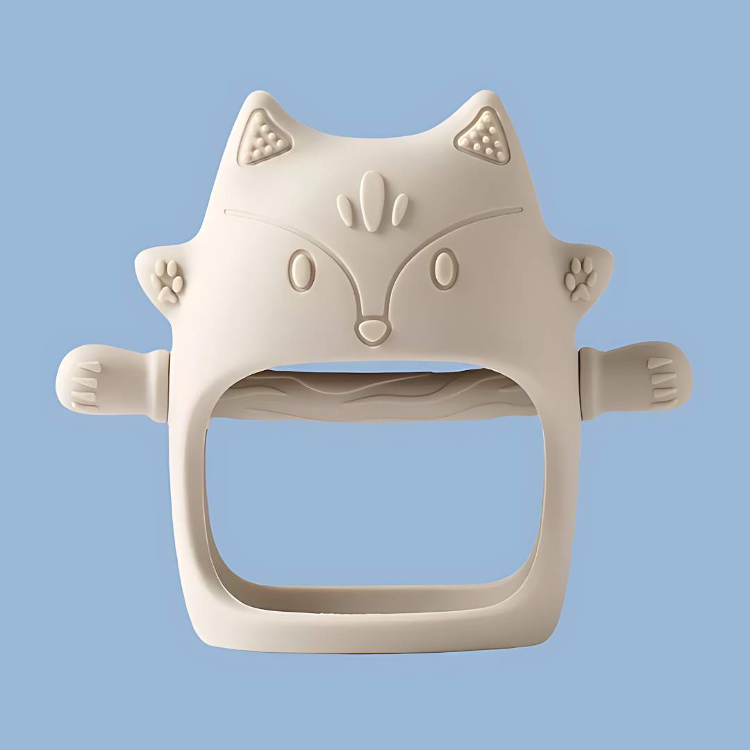 A cream-colored, cat-shaped silicone baby teether, features embossed ears, eyes, nose, mouth, and whisker details, cat-shaped silicone, embossed design, silicone teether